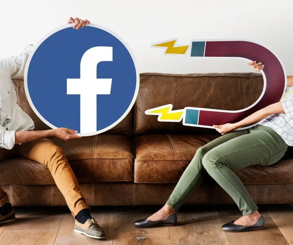 két ember tart egy mágnest és egy facebook ikont, szemléltetve a facebook hirdetéseket